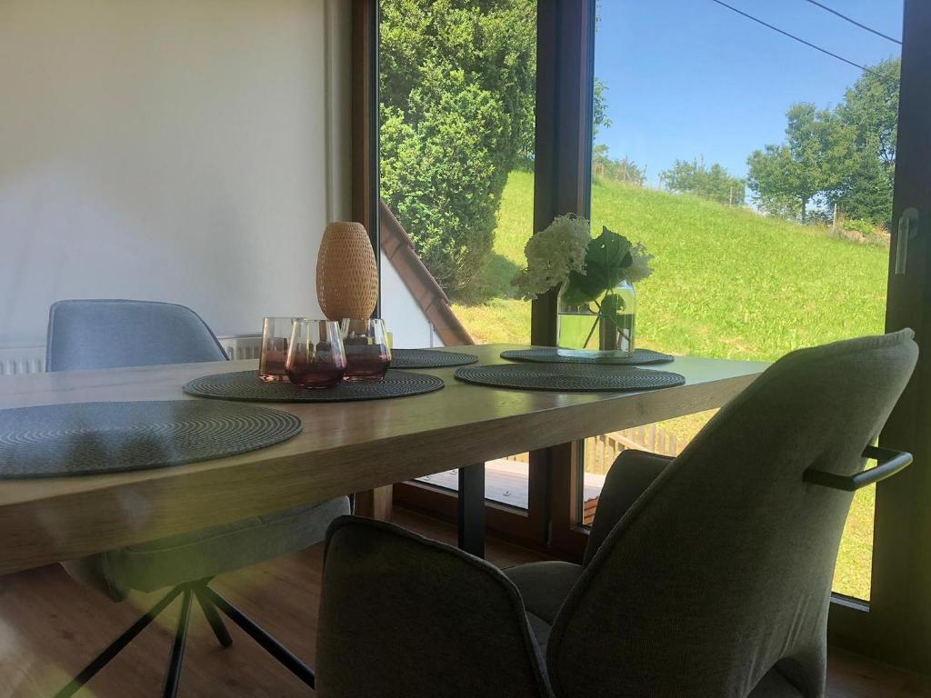 a dining room table with chairs and a large window at s´Raubers in Bühlertal