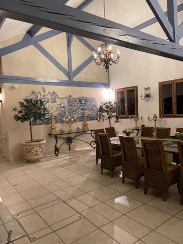 uma sala de jantar com mesa e cadeiras em Grande villa d'exception en Normandie tennis, piscine, jacuzzi, salle de fitness em Muids