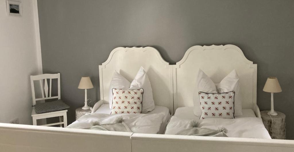 ein weißes Bett mit zwei Kissen im Schlafzimmer in der Unterkunft Guest House Dommitzsch in Dommitzsch