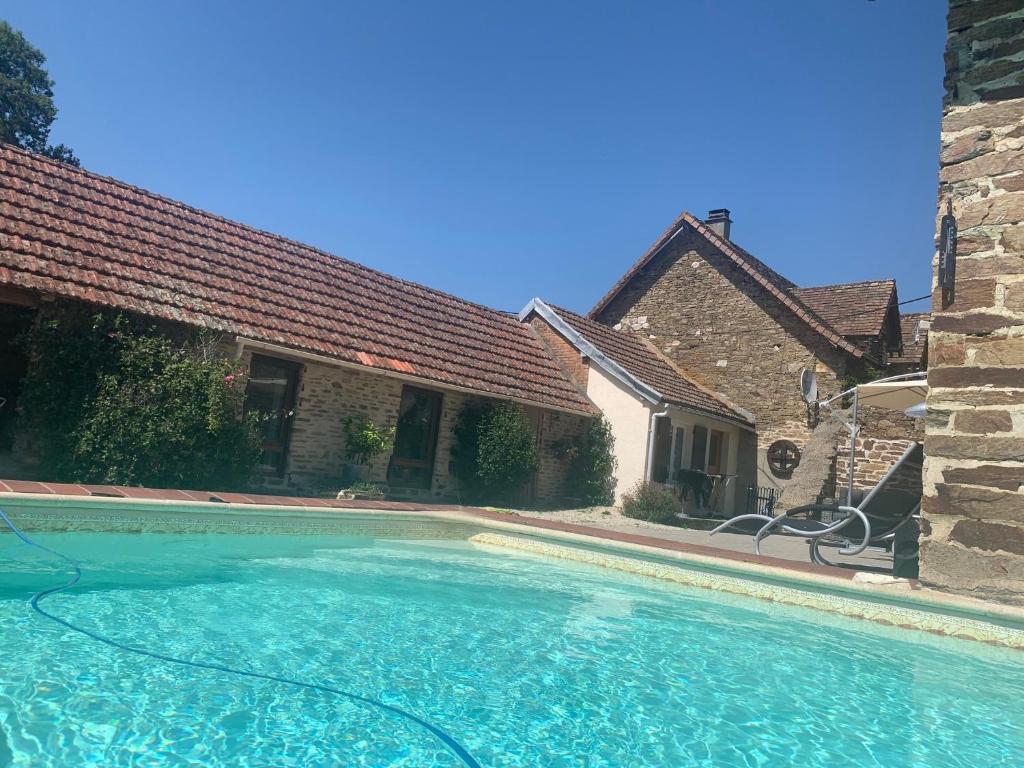 a swimming pool in front of a house at La Petite Ecurie in Saint-Yrieix-la-Perche