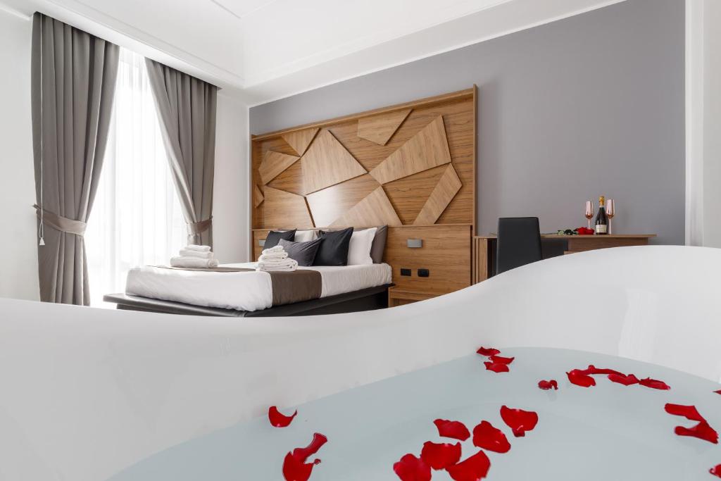 a bedroom with a bed with red rose petals on it at Sant'Angelo Suites in Naples