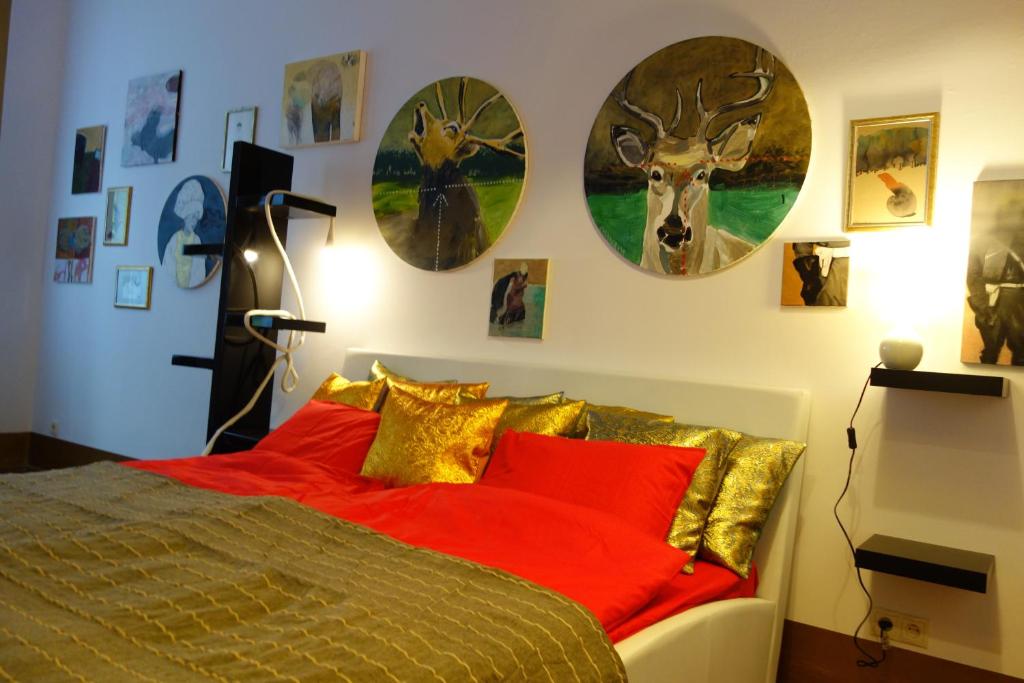 クラクフにあるSebastian Goldのベッドルーム1室(赤い枕と壁に時計が付いたベッド1台付)
