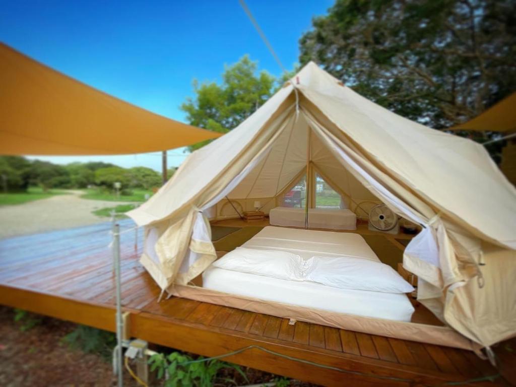 a bed in a tent on a wooden deck at Pitahaya Glamping in Cabo Rojo
