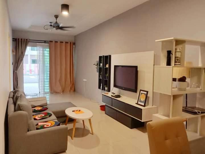 a living room with a couch and a tv at QC Homestay - Room Only in Pusing