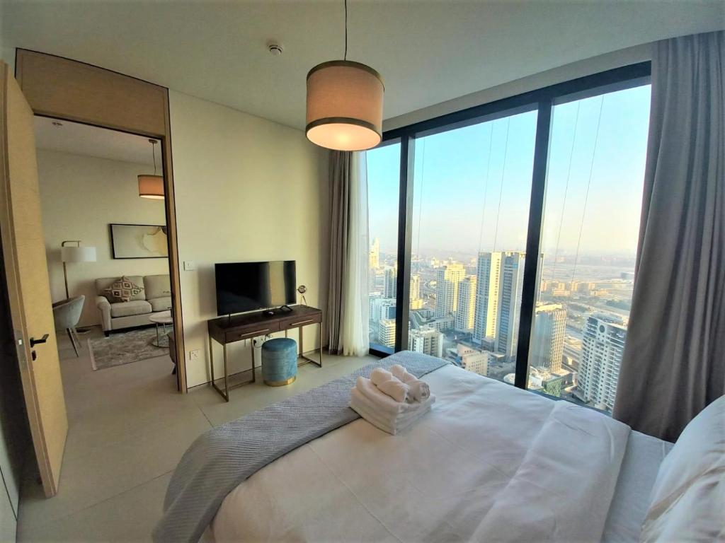 a bedroom with a white bed and a large window at Luxury at The Address Jumeirah Beach Residence in Dubai