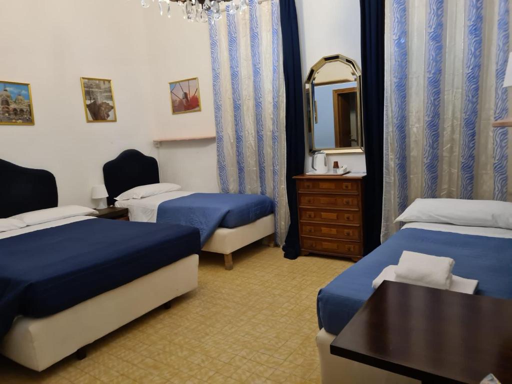 ヴェネツィアにあるAlloggi alla Scala del Bovoloのベッド2台と鏡が備わるホテルルームです。