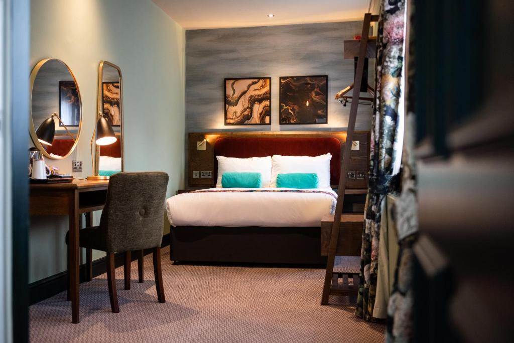 a hotel room with a bed and a desk and a bedroom at The Pine Marten by Innkeeper's Collection in Harrogate