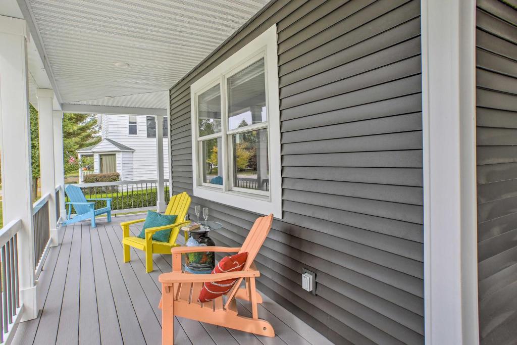 a porch with chairs and a dog sitting in a chair at Bright Lower-Level Unit about 1 Mile to Lake Mich in Ludington