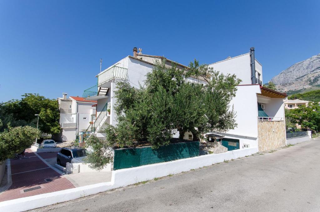 a white building with a tree in front of it at House Nikola in Tučepi