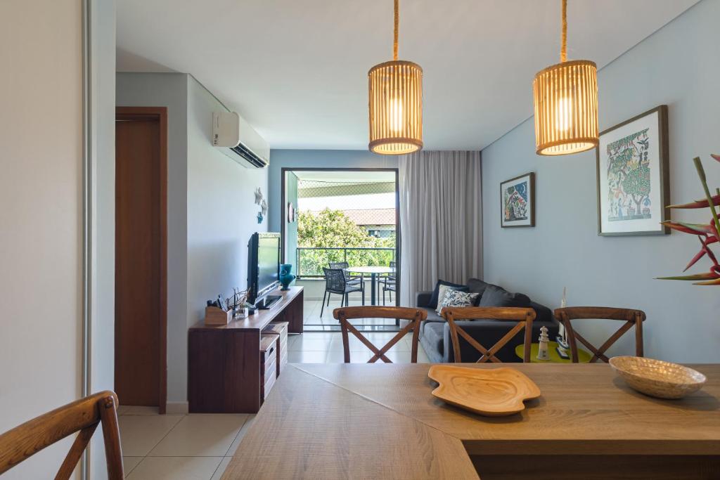 a kitchen and living room with a table and a television at Carneiro Beach Resort 305 in Tamandaré