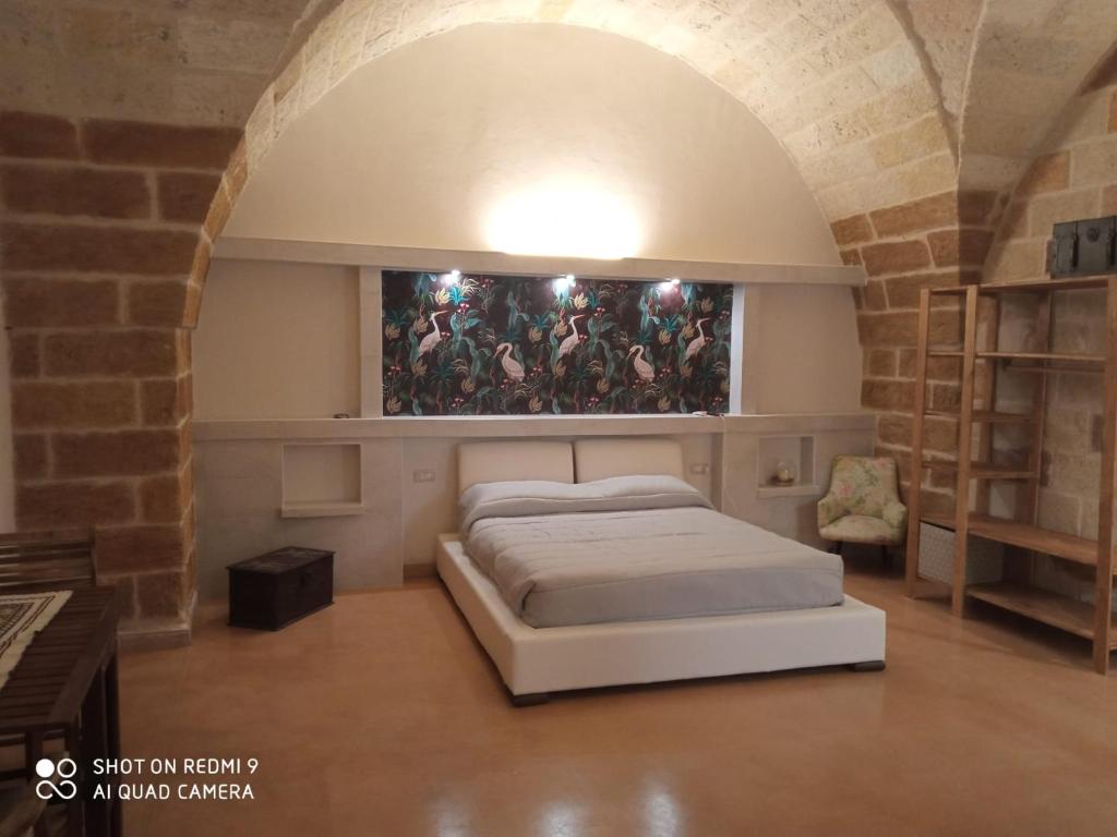 Bett in einem Zimmer mit Wandgemälde in der Unterkunft La conigliera in Brindisi