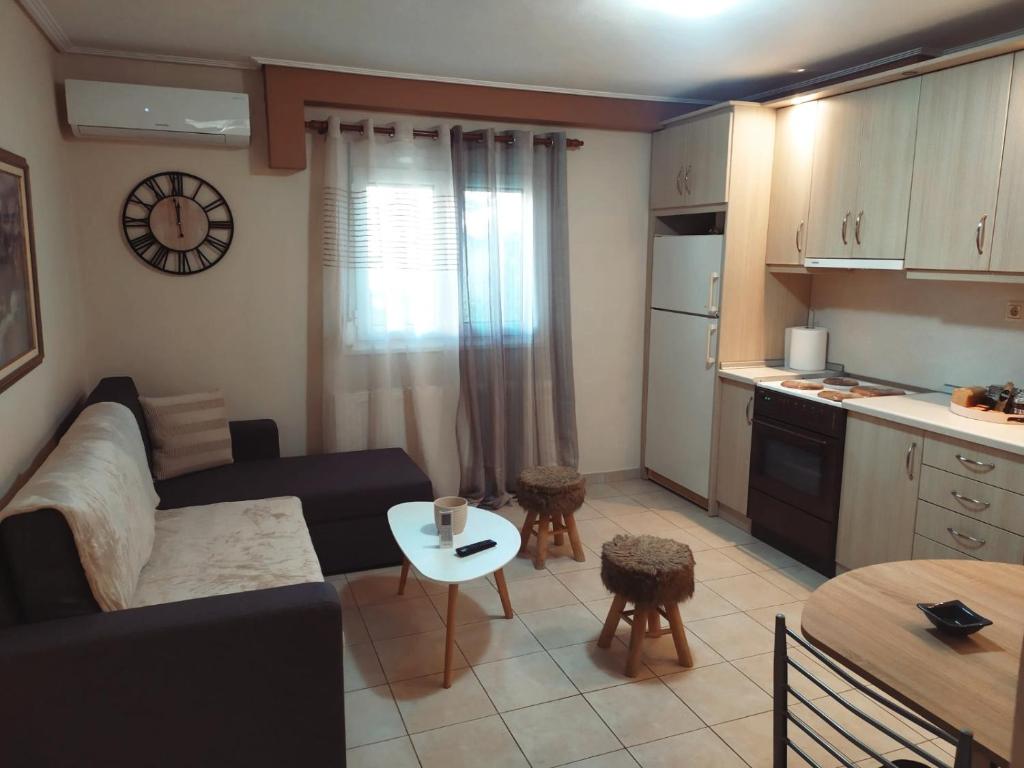 a living room with a couch and a table and a kitchen at Apartment near the sea, Volos in Volos