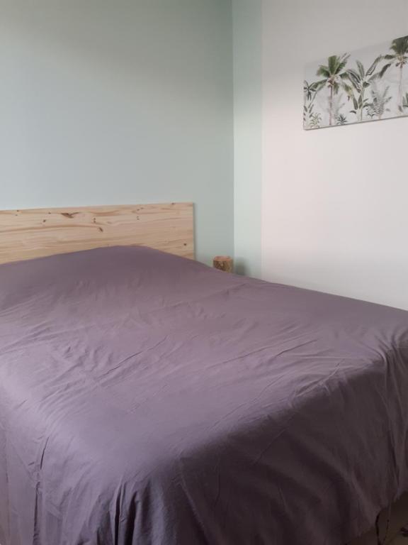 レ・サ​​ーブル・ドロンヌにあるLes Sables d'Olonneの紫の毛布が敷かれたベッド