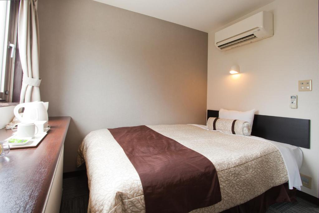 Postel nebo postele na pokoji v ubytování Kakegawa Station Hotel