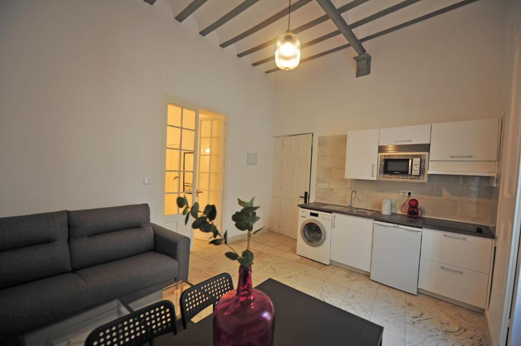 sala de estar con sofá y jarrón sobre una mesa en Apartamentos Casa Rosaleda, en Jerez de la Frontera