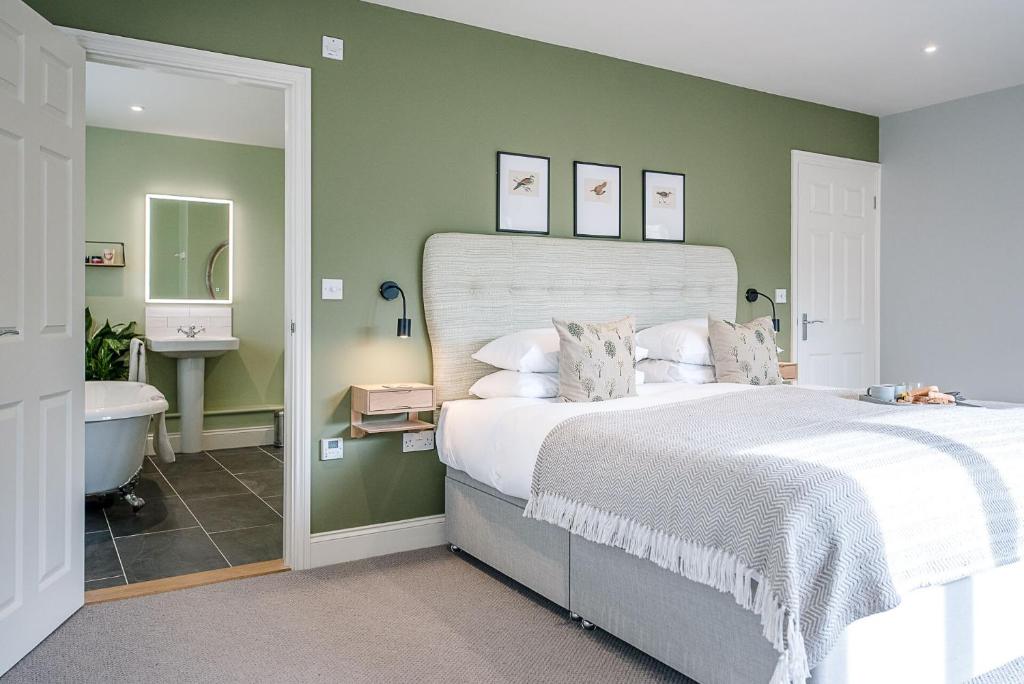 a bedroom with a large bed and a bathroom at Festival House, Snape in Saxmundham