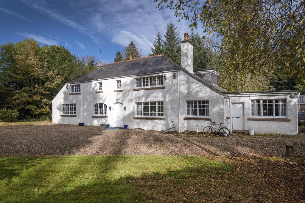 a white house with a bike parked in front of it at Finest Retreats - The White House of Park in Cornhill