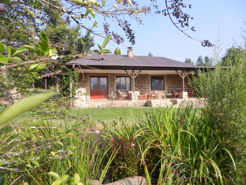 a brick house with a garden in front of it at Watersmeet cottages in Dullstroom