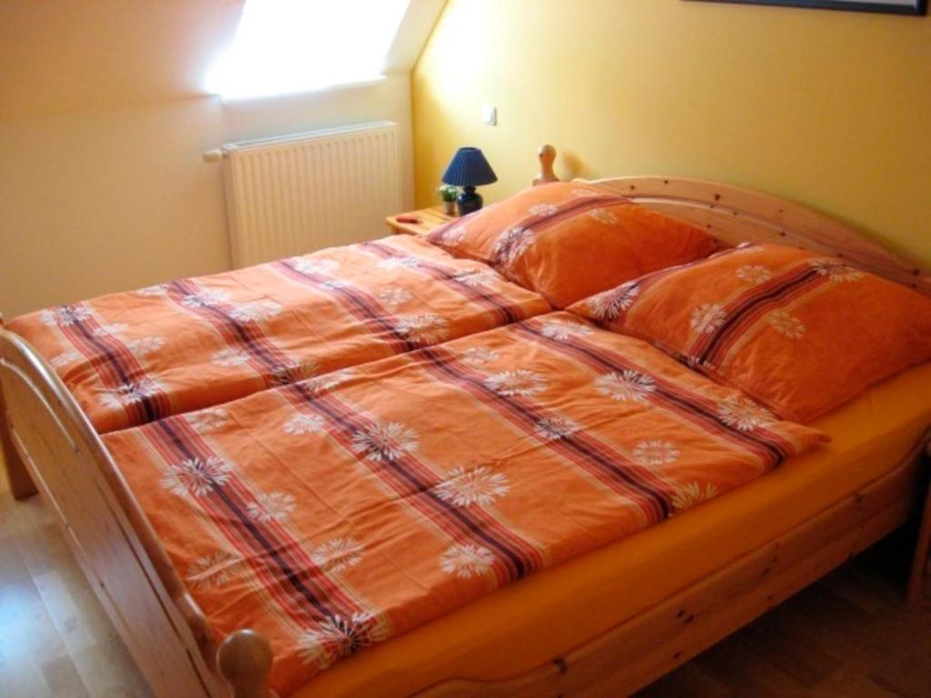 a bed in a bedroom with a blanket on it at Ferienwohnung Bünz in Schülp