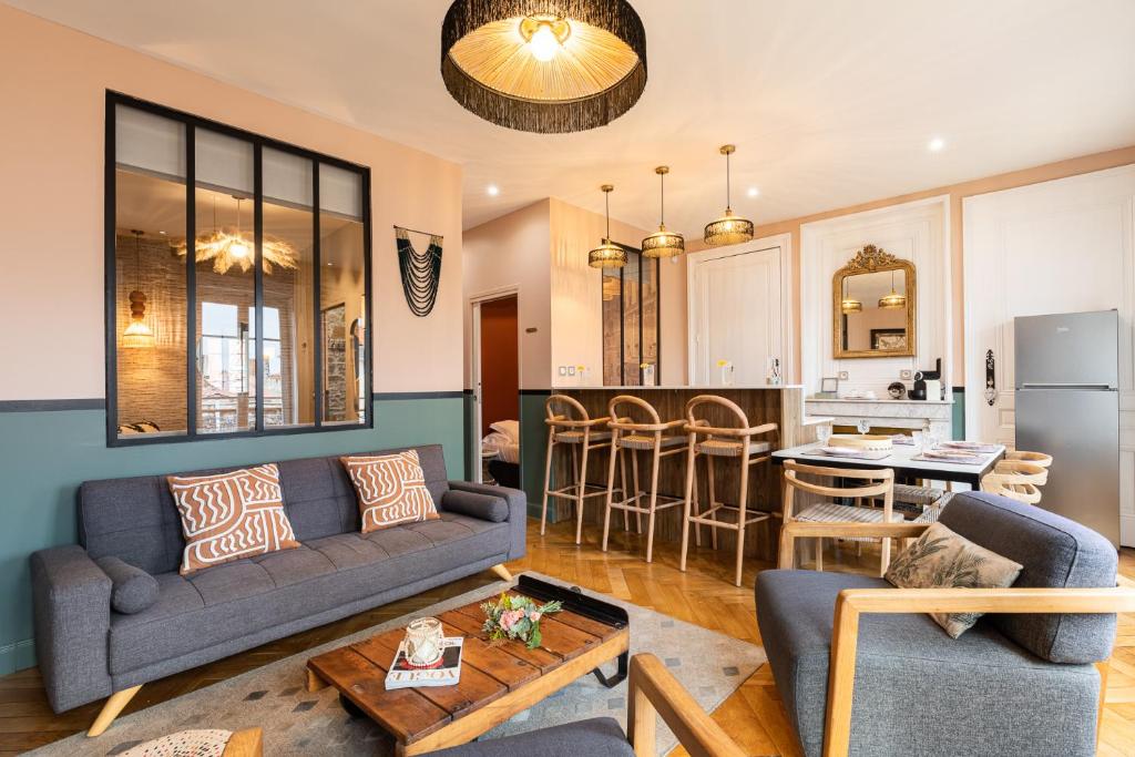 a living room with a couch and a kitchen at Host inn Lyon - Hypercentre Vieux Lyon in Lyon