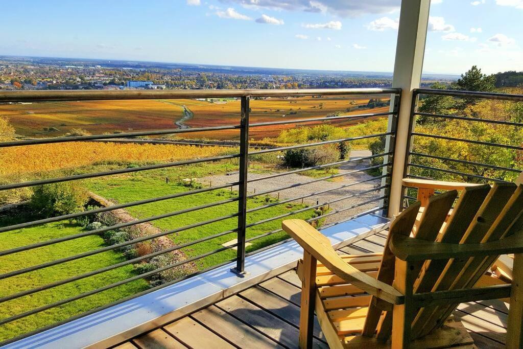 einen Balkon mit einem Stuhl und Blick auf ein Feld in der Unterkunft La Maison de l'Ecu : charme et vue incroyable in Beaune