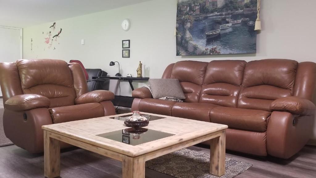 a living room with a brown leather couch and a coffee table at Sacred Pilgrimage Studio in Metchosin