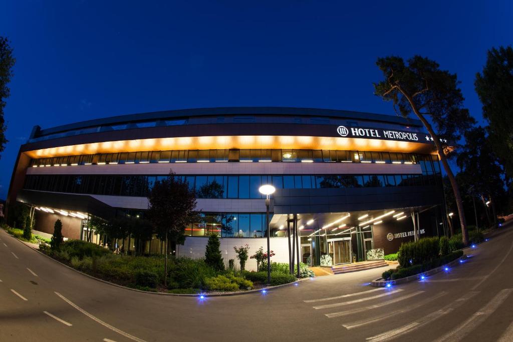 a large building with lights in the night at Metropolis Hotel in Bistriţa