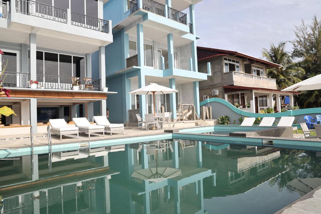 a swimming pool in front of a building at Grace Wave Resort in Hilibotodane