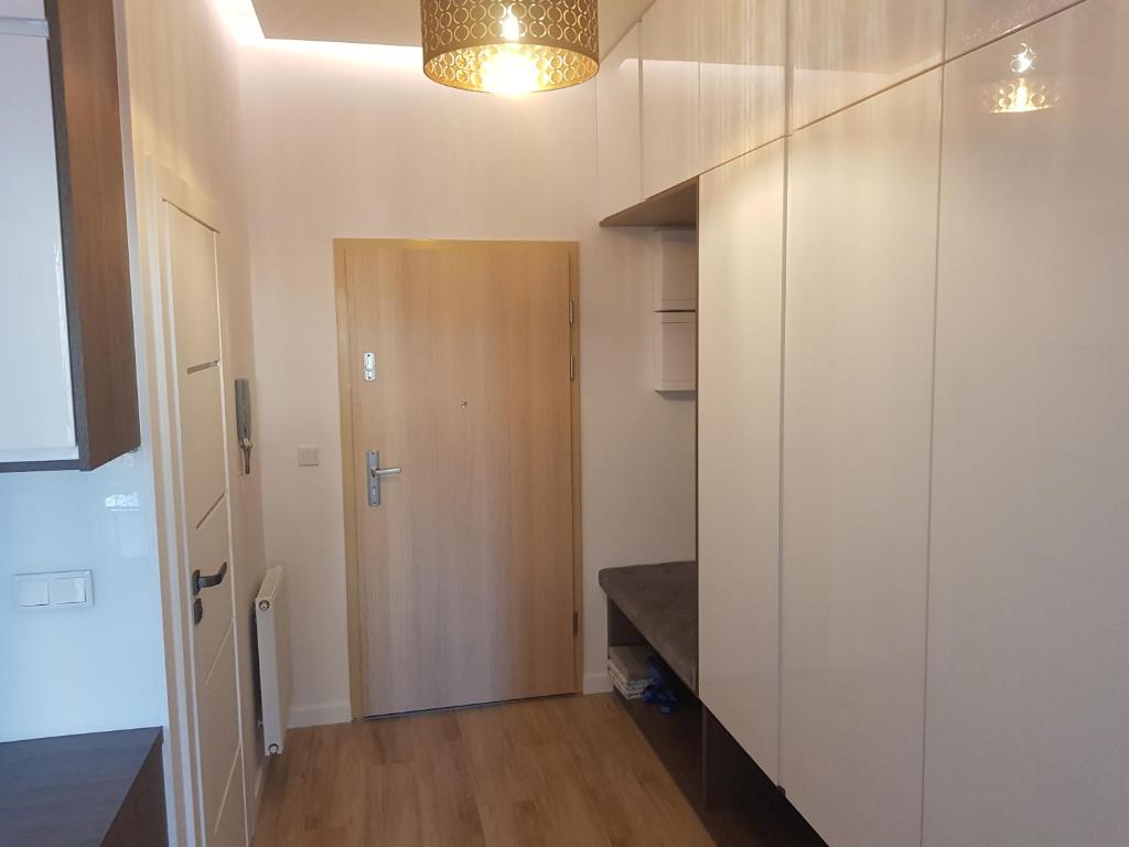 um quarto com um corredor com uma porta e uma mesa em Apartament Skarbowa em Leszno