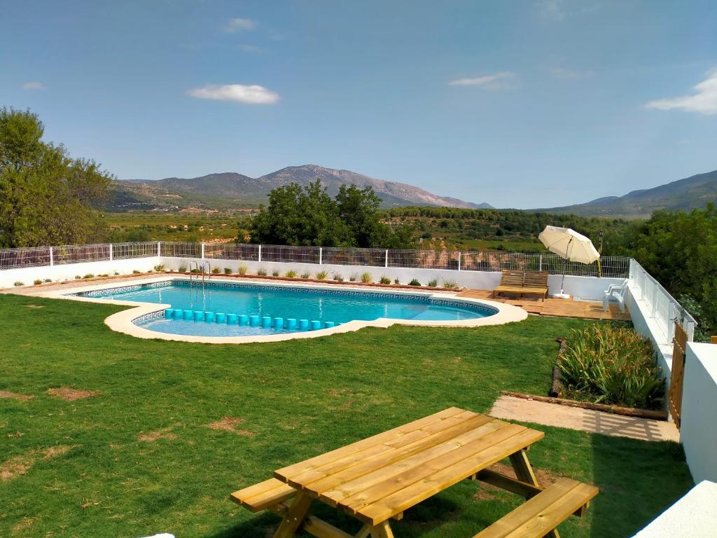 una piscina con mesa de picnic y banco en Más del Sandungo, en Els Ibarsos