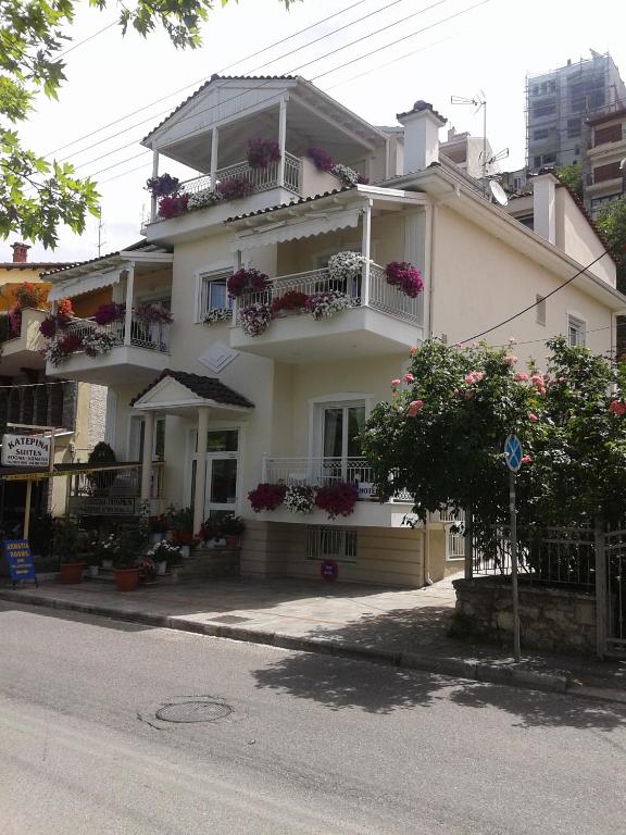 a white house with flower boxes on the balconies at Paraliako Κaterina Lakefront - Biker Friendly Hotel in Kastoria