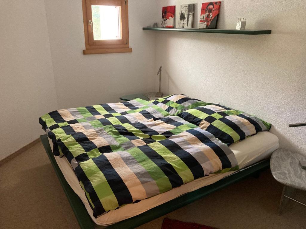a bed with a colorful blanket on it in a room at Casa Selva 2000 Fl Whg Nr 2 in Lenzerheide