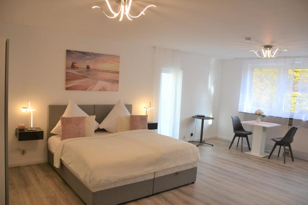 Schlafzimmer mit einem Bett, einem Tisch und Stühlen in der Unterkunft Sophie Superior Apartment in Karlsruhe