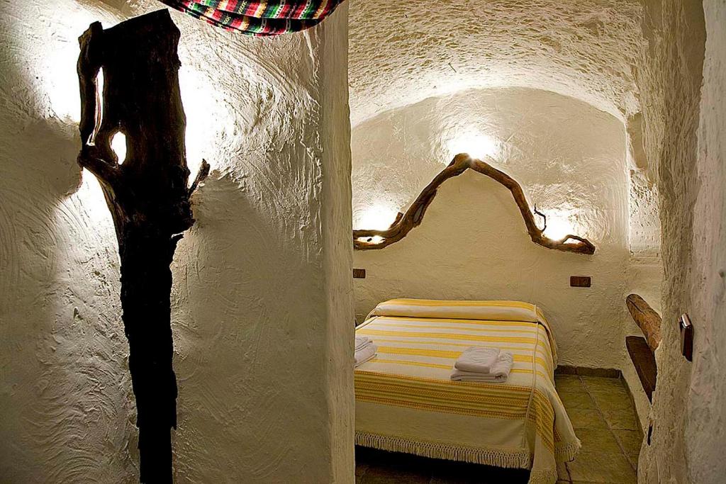 um quarto com uma cama num quarto branco em Cuevas La Atalaya em Huéscar
