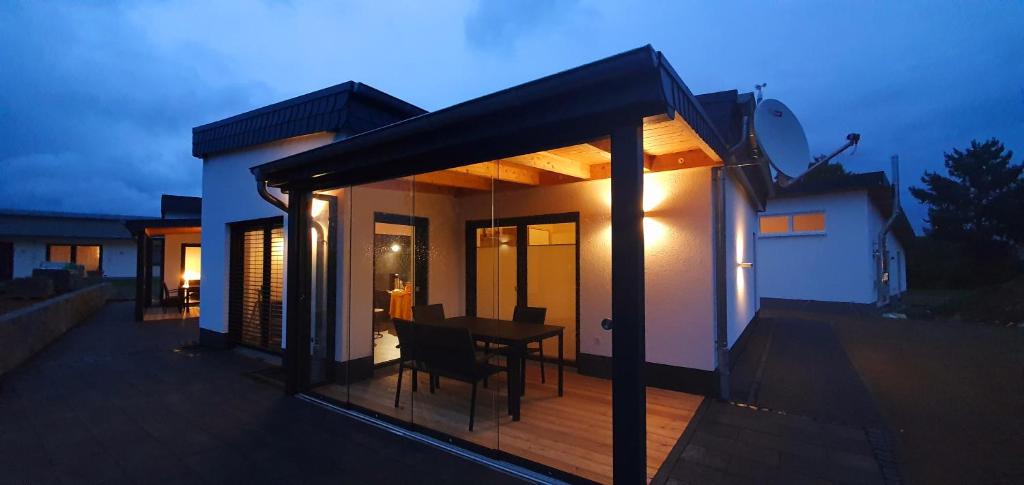 une maison avec une terrasse munie d'une table. dans l'établissement Ferienhäuser Brieden - "Haus Pommerbach" & "Haus Wegwarte", à Brieden