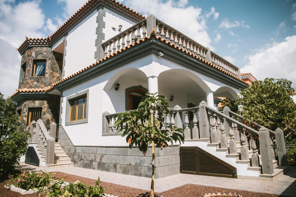 a white house with a staircase in front of it at Villa Cervantes Sonnenland con piscina privada climatizada in Maspalomas