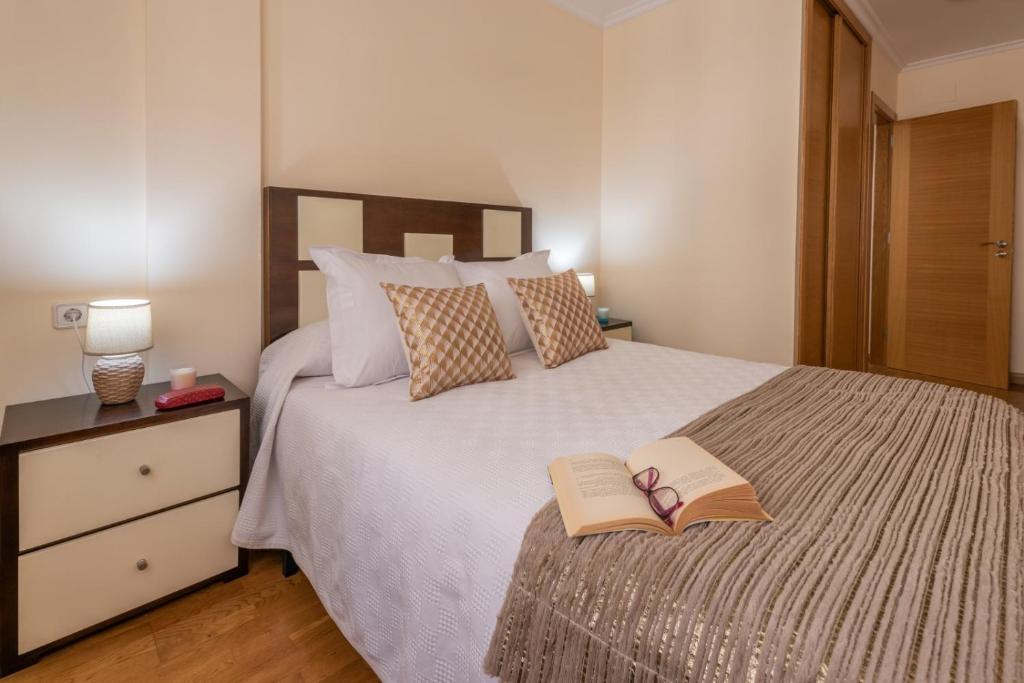a bedroom with a bed with two books on it at apartamento centro sanxenxo con parking gratis in Sanxenxo