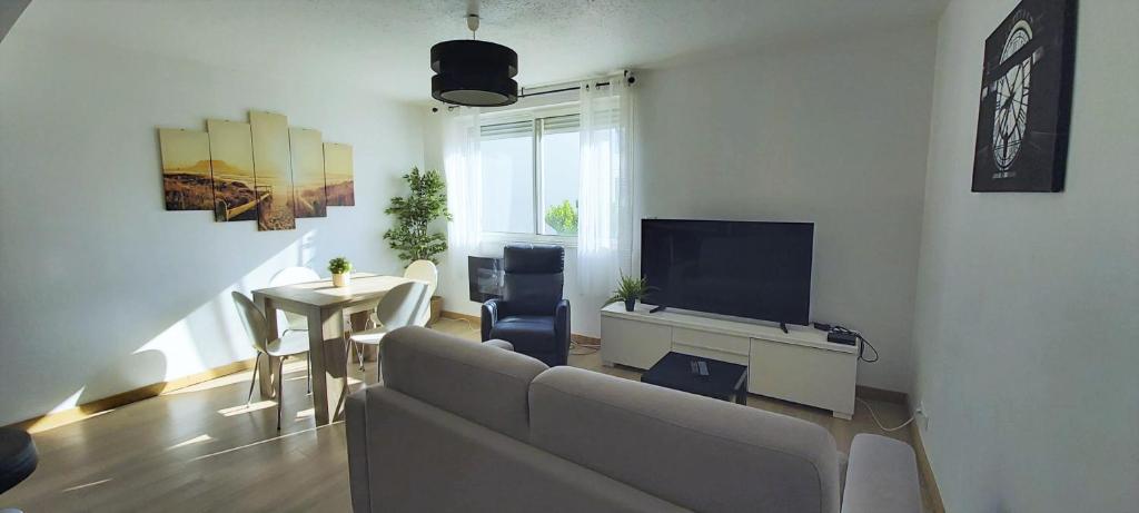 un salon avec un canapé, une télévision et une table dans l'établissement Miracle Morning, à La Grande Motte
