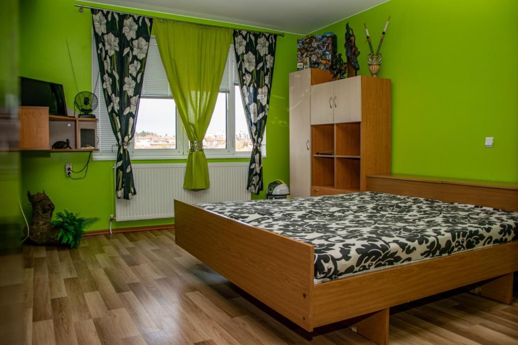 a bedroom with a bed in a room with green walls at Vilhelmov’s apartament in Lukovit