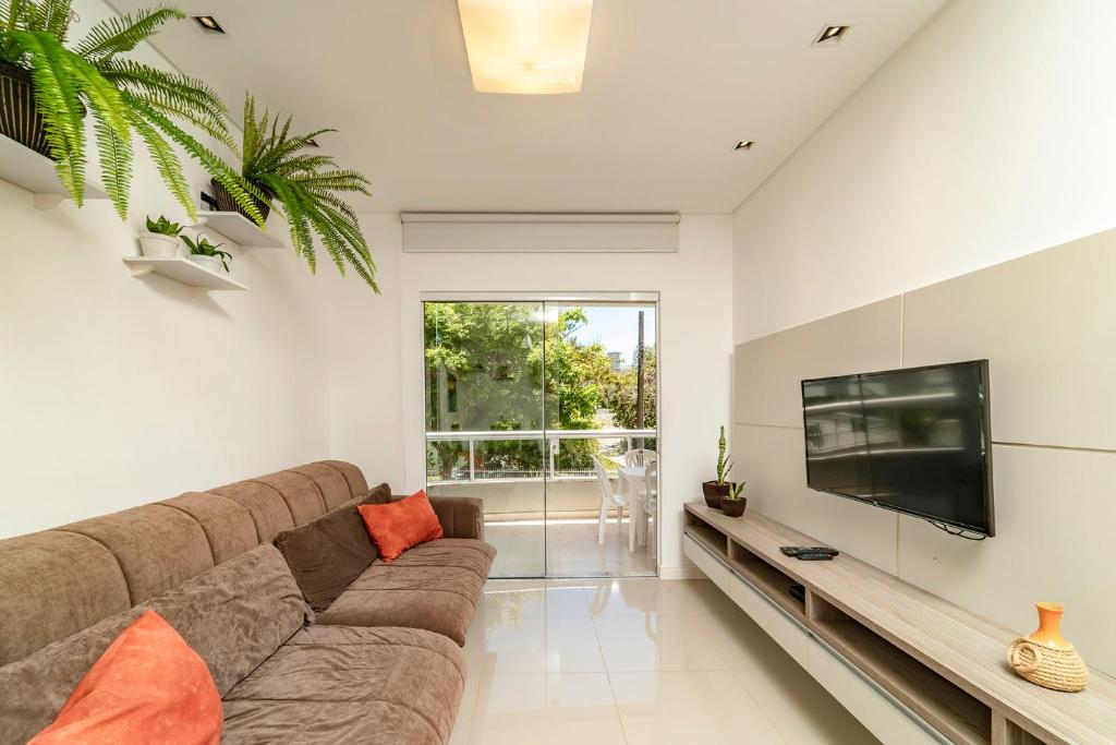 sala de estar con sofá grande y TV de pantalla plana en Refúgio dos Pássaros - Bombinhas - Casa Da Ca, en Bombinhas