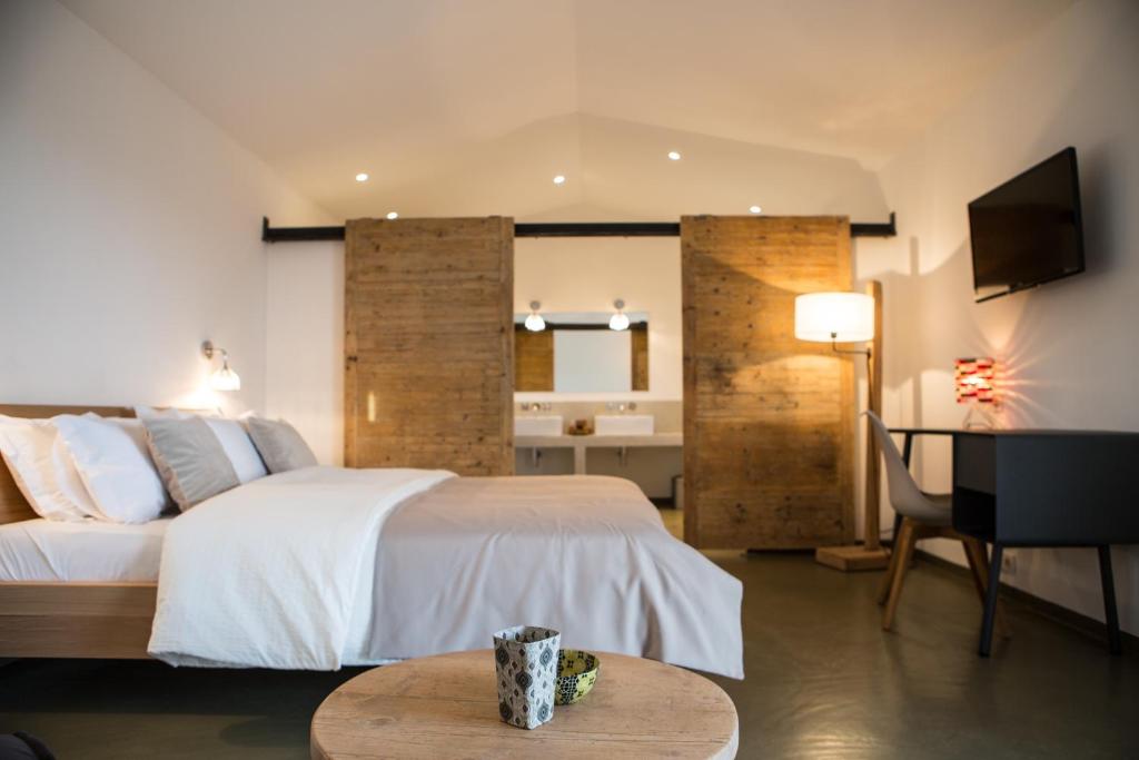 a bedroom with a white bed and a table in a room at Hotel Les Chambres de Mila Bonifacio in Bonifacio