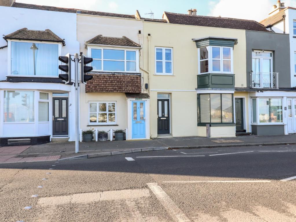 an empty street with a traffic light in front of a house at La Plage in Deal