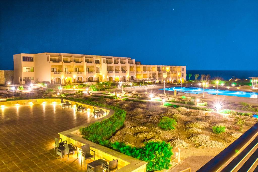a hotel at night with the ocean in the background at Viva Blue Resort and Diving Sharm El Naga (Adults Only) in Hurghada