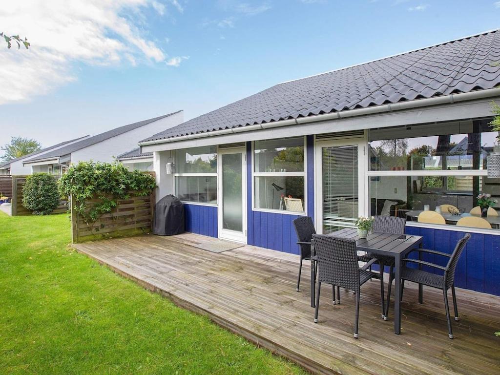 a wooden deck with a table and chairs on a house at 6 person holiday home in V ggerl se in Marielyst