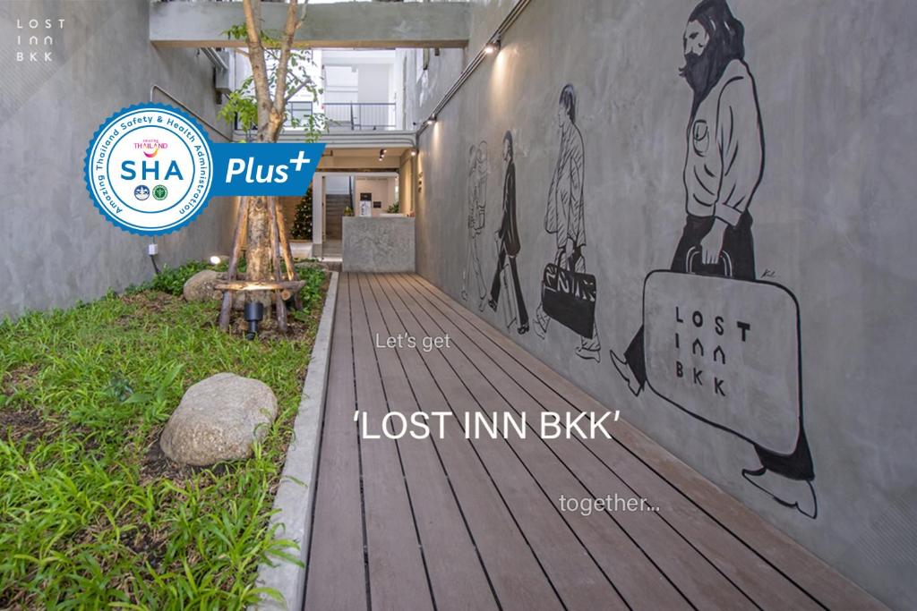 un mural de un hombre con una maleta en la pared en Lost Inn BKK, en Bangkok