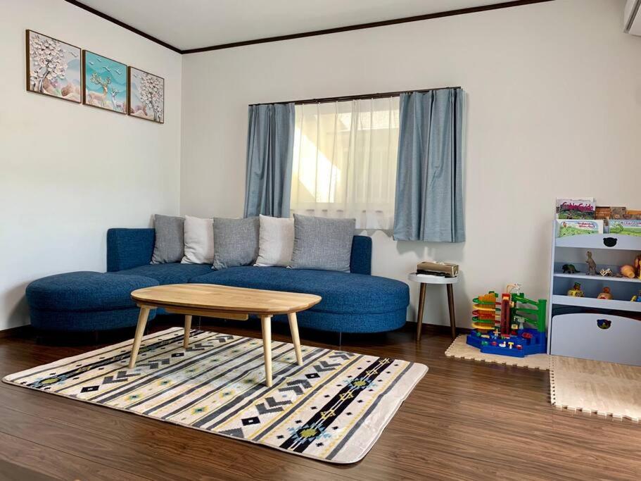 a living room with a blue couch and a table at Nara Family HOUSE in Nara
