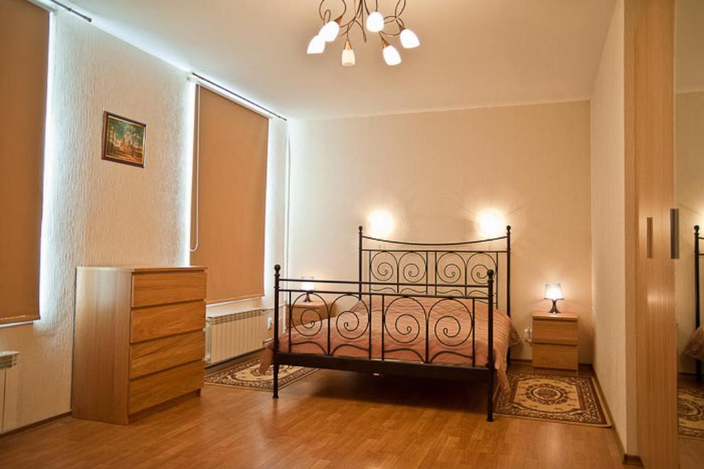 a bedroom with a bed and a dresser and a window at Piterstay Apartments - Saint Petersburg in Saint Petersburg