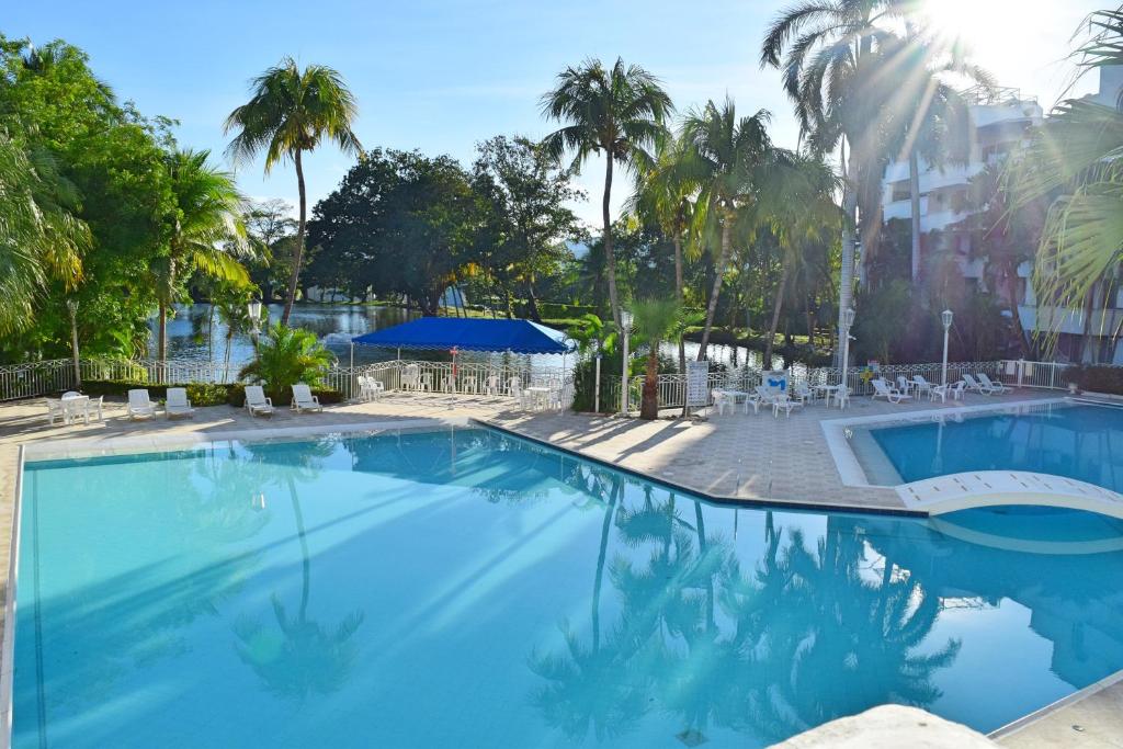 une grande piscine avec des palmiers en arrière-plan dans l'établissement Cristales, Condominio Lagos del Peñon, à Girardot
