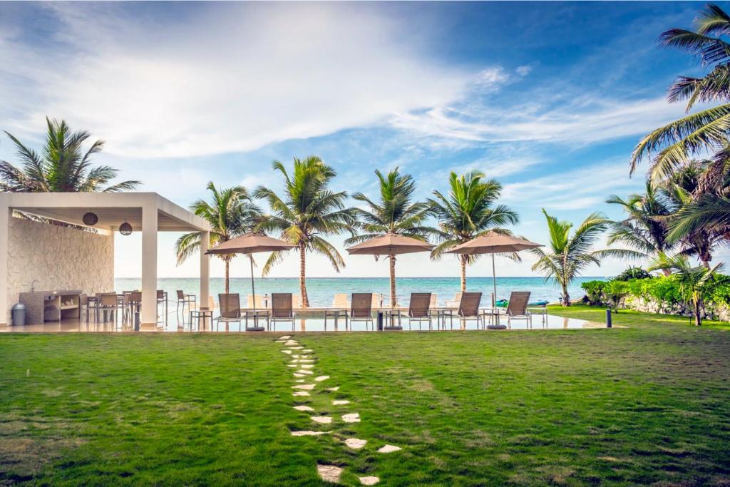 een voetafdruk in het gras voor het strand bij ApartHotel Ebb Ti Kaan Tulum-Luxury Condos- in Tulum