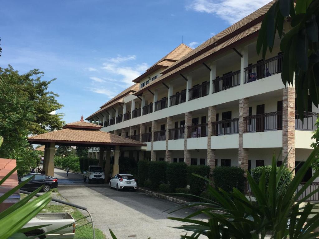 a building with a car parked in a parking lot at phuriburi resort in Pattaya Central